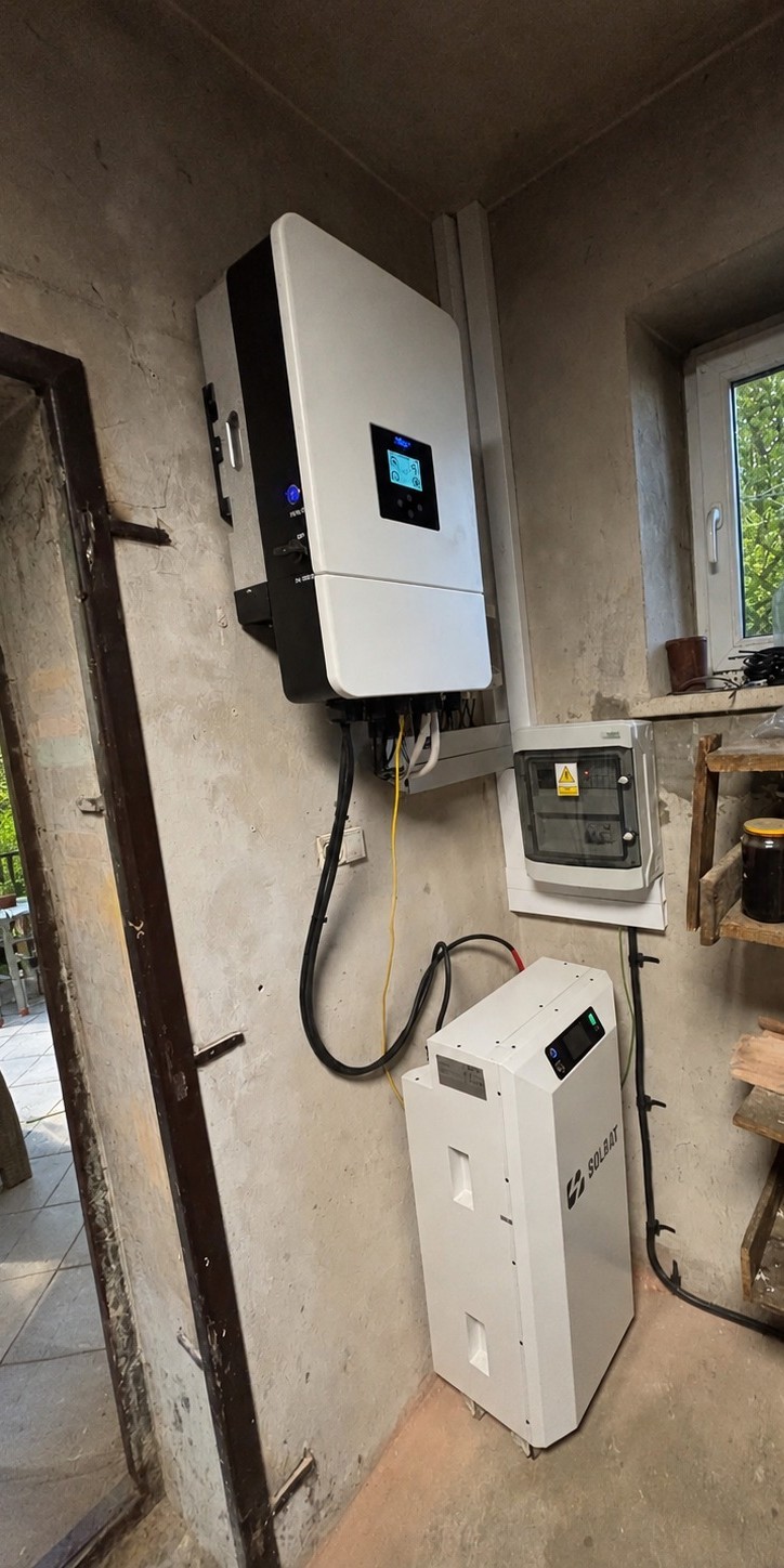 Falownik hybrydowy i stojący magazyn energii zamontowane na ścianie pomieszczenia technicznego